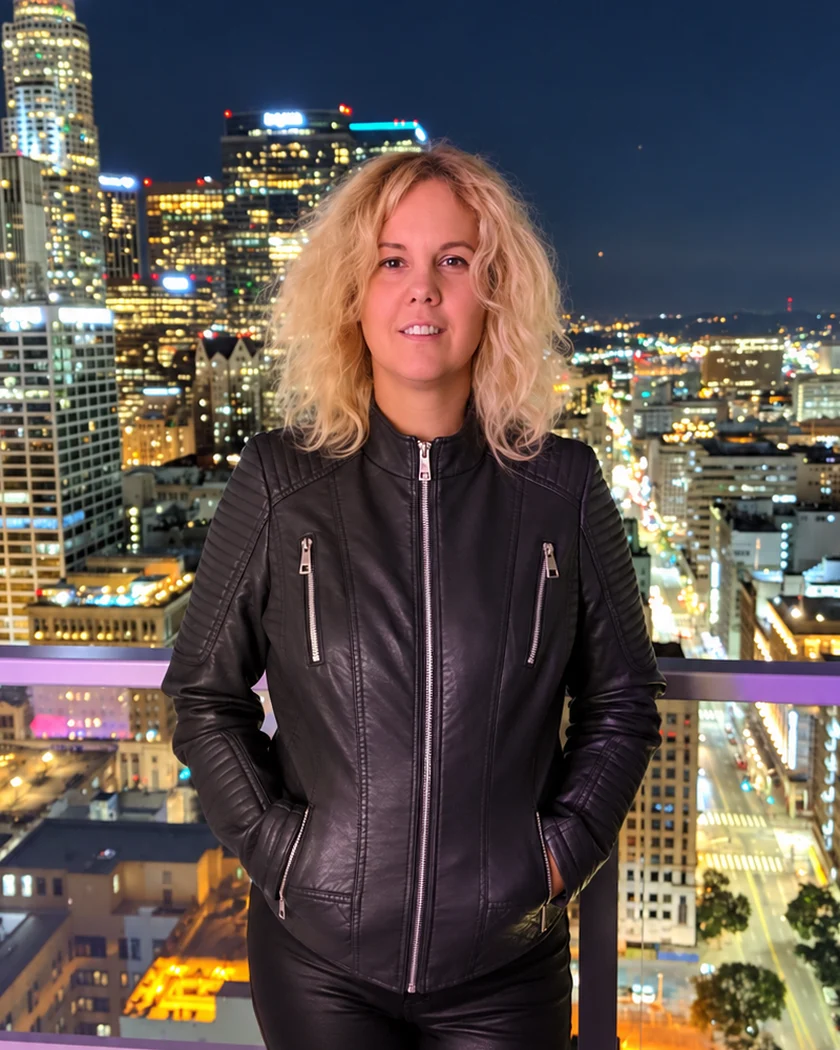 Korinna Leányvári at night, with the lights of the city behind her